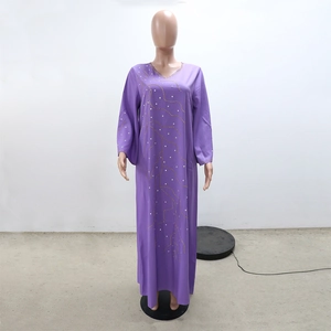 Détail de la robe caftan violette ample avec motifs de vagues dorées et strass brillants
