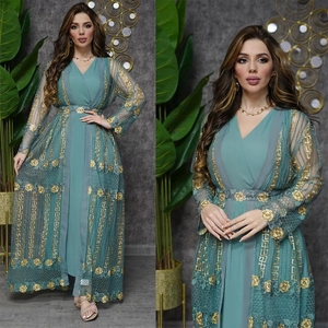 Detail eines blaugrünen Kaftan-Sets mit goldener Blumenstickerei und Paillettenbesatz