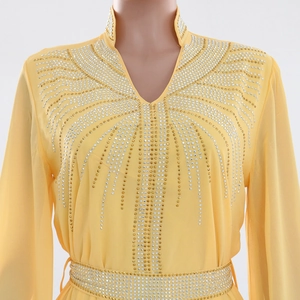 Detail of golden rhinestones on yellow chiffon kaftan dress with intricate patterns