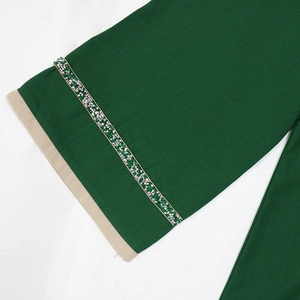 Détail de la manche de jalabiya vert foncé avec ruban en strass et bordure beige