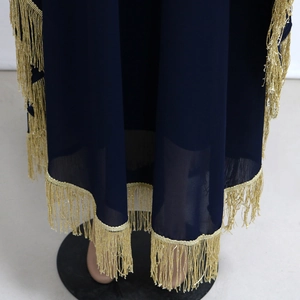Gros plan sur l'ourlet du caftan bleu marine avec d'élégantes franges dorées