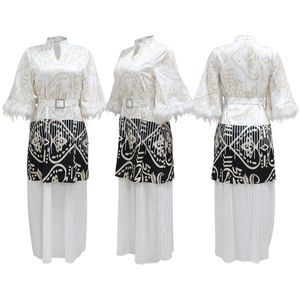 Detail eines bedruckten Kaftan-Kleides mit weißen Federbündchen und Faltenrock