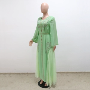 Detail of mint green kaftan dress with exquisite floral embroidery and sequin embellishments