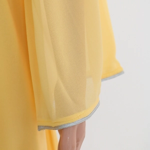 Detailed view of yellow chiffon kaftan sleeve with elegant silver trim decoration
