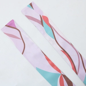 Close-up of abstract printed silk scarves with colorful artistic patterns on white background
