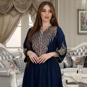 Detail of colorful leaf embroidery on navy blue kaftan dress with ethnic patterns