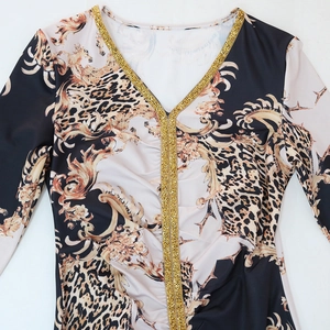Detail of V-neckline featuring golden rhinestones on leopard and baroque print dress