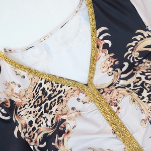 Detail of V-neckline with gold rhinestone trim and baroque leopard print on kaftan dress