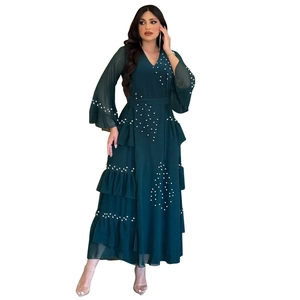 Detail of elegant dark green chiffon dress with beaded white pearls and layered ruffles