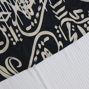 Detailaufnahme des Tribal-Ethno-Prints auf glattem schwarzem Stoff mit präzisen Nähten