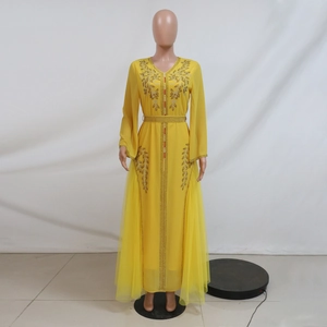 Detail view of yellow kaftan dress with intricate rhinestone embroidery and chiffon mesh