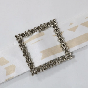Detail der silbernen Metallschnalle an einem weiß bedruckten Gürtel für Kaftan