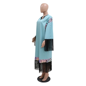 Detail of light blue tunic dress showing black fringe hem and iridescent sequin patterns