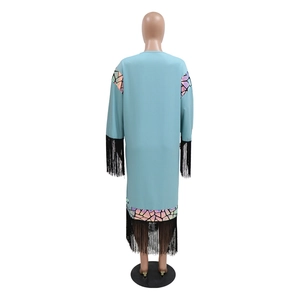 Detail of light blue robe dress featuring black fringe trim and iridescent sequins