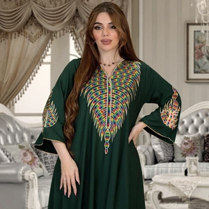 Detail showing colorful embroidery on the V-neckline and sleeves of a dark green kaftan