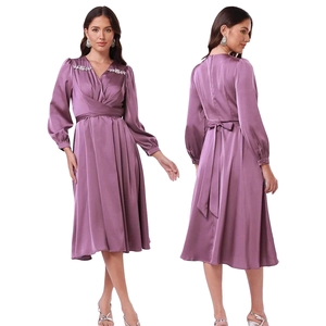 Detail eines lila Satin-Midikleids mit V-Ausschnitt-Wickeldesign und glitzernden Strasssteinen