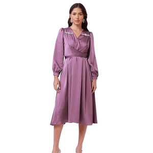 Detail eines lila Satin-Midikleids mit V-Ausschnitt und Diamantblumen-Schulterverzierung