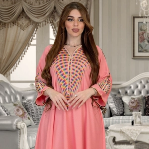 Detailed close-up of colorful geometric embroidery on a pink V-neck kaftan maxi dress