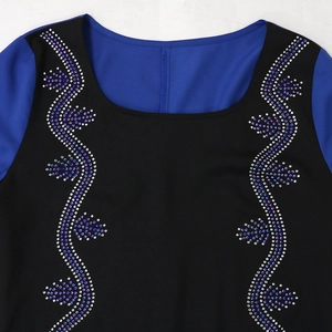 Detail of round neckline with blue rhinestone leaf patterns on black fabric top