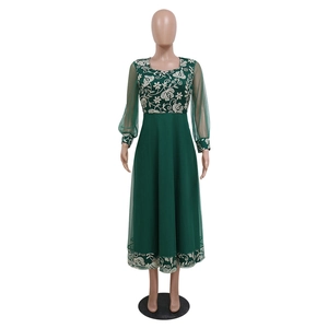 Close-up of white floral embroidery on dark green kaftan dress with mesh sleeves