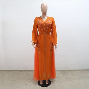 Detail of bright orange kaftan dress with gold embroidery and sparkling rhinestones