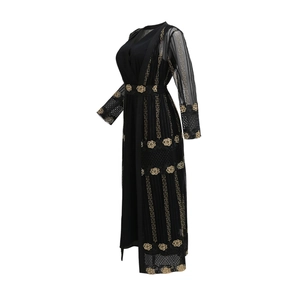 Detail eines schwarzen Kaftans mit goldener Blumenstickerei und griechischem Muster auf Netz