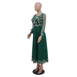 Detail of white floral embroidery on dark green kaftan dress with sheer mesh sleeves