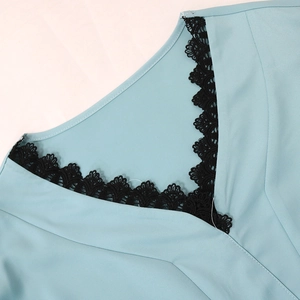Close-up of V-neckline with black lace trim on light blue sequin tassel dress