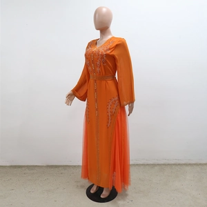 Detail of beaded sequins and embroidery on orange kaftan dress sleeve and belt