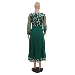 Detail of elegant dark green kaftan dress featuring floral embroidery on mesh back