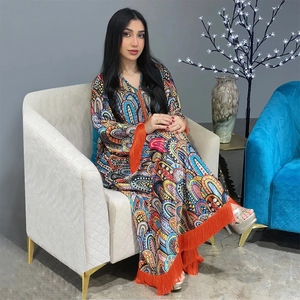 Détail de robe caftan à imprimé cachemire avec de longues franges orange sur les manches