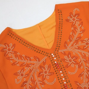 Detailed close-up of orange V-neck dress with handcrafted beadwork and rhinestones