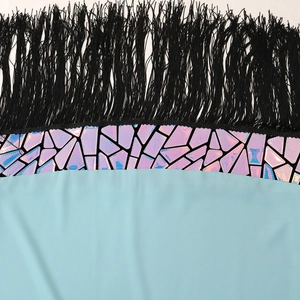 Detail view of iridescent geometric patterns and black fringe tassels on the dress