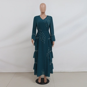 Detail of the teal chiffon maxi dress featuring delicate white pearl beadwork and layered ruffles