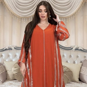 Close-up of vertical silver sequins on the orange loose-fit chiffon kaftan dress