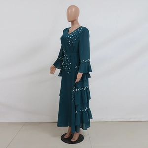 Detailed view of white pearl beading on a dark green layered chiffon maxi dress sleeves