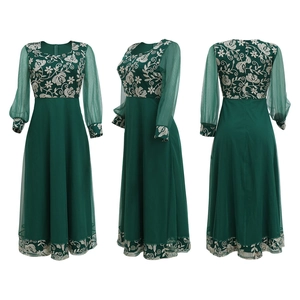 Detail of dark green kaftan dress featuring white floral embroidery and sheer mesh sleeves