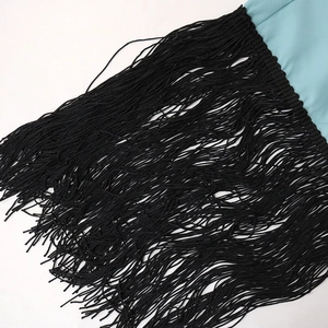 Detailed macro shot of blue sequin dress fabric with dense black fringe tassels