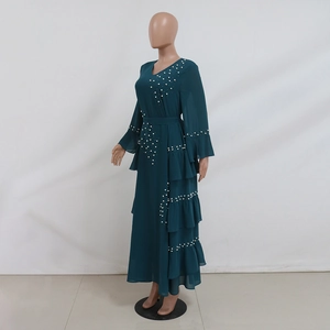 Detail of beaded pearls and ruffled asymmetrical layers on dark green chiffon maxi dress