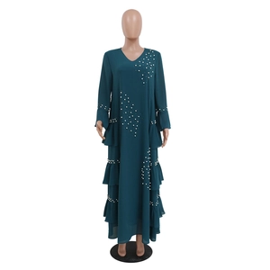 Detailed close-up of dark green chiffon maxi dress with pearl beading and ruffled tiers
