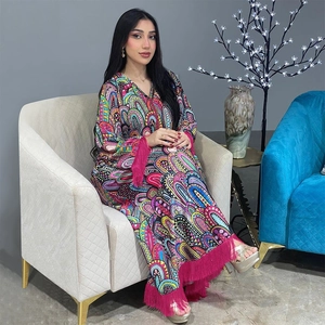 Gros plan sur un caftan bohème coloré avec des motifs éclatants et des franges rose vif