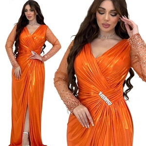 Detail of orange evening gown featuring a beaded V-neck and sparkling rhinestone waist buckle