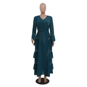 Detail of elegant dark green chiffon maxi dress with pearl beading and tiered ruffle hem