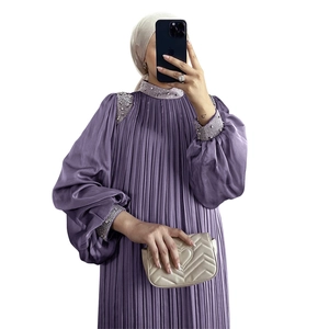 Détail macro d'une robe longue plissée violette avec sequins et broderies de perles