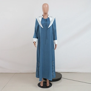 Detail view of contrast white lapels with hollow embroidery on blue jalabiya dress