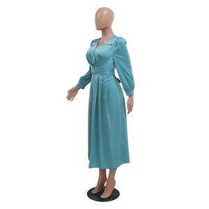 Nahaufnahme vom V-Ausschnitt mit Kristallbesatz am tiffanyblauen Satin-Midikleid
