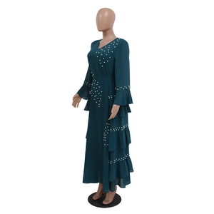 Detail of elegant dark cyan chiffon dress with beaded pearls and ruffled layered hemline