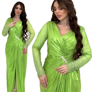 Detail of emerald green evening gown featuring sequined sleeves and rhinestone buckle waist