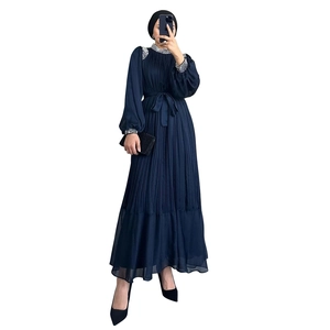 Détail d'une robe abaya plissée bleu marine avec perles argentées et ourlet en mousseline