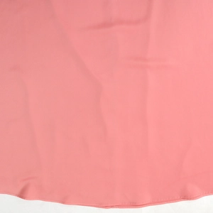 Close-up of coral pink embroidered robe dress showing fabric texture and hemline stitching